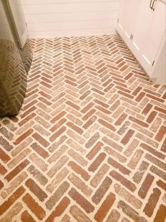 a bathroom with a brown and white herringbone pattern on the floor next to a toilet