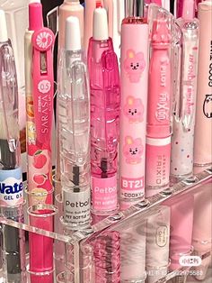 a clear shelf filled with lots of different types of pens