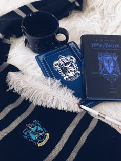 two harry potter notebooks and a pen on a white furnishing with a black mug