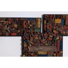 three pieces of art made out of wood with different colors and shapes on the wall