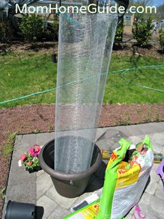 a large metal tube sitting on top of a cement slab next to a potted plant