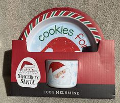 there is a cup and saucer set in the box with santa's hat on it