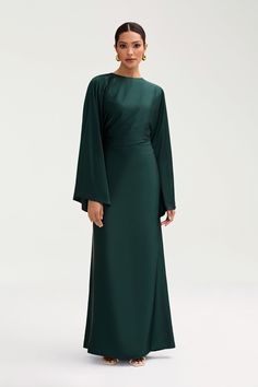 The Batool Dress is meant to have an oversized body design, complimented by an adjustable tie wrap. Size down if in between sizes. Indulge in luxury with the Batool Satin Maxi Dress. Its loose wide sleeves and lustrous satin fabric exude elegance, while the adjustable tie waist flatters your figure. Versatile design ma Elegant Green Dress With Kimono Sleeves, Elegant Long Sleeve Silk Dress With Draped Sleeves, Evening Dresses With Kimono Sleeves In Satin, Evening Satin Dresses With Kimono Sleeves, Satin Evening Dress With Kimono Sleeves, Elegant Bell Sleeve Maxi Dress For Formal Occasions, Elegant Formal Maxi Dress With Bell Sleeves, Party Dresses With Draped Kimono Sleeves, Elegant Silk Dress With Kimono Sleeves