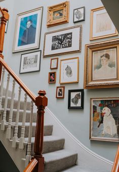 a staircase with many framed pictures on the wall