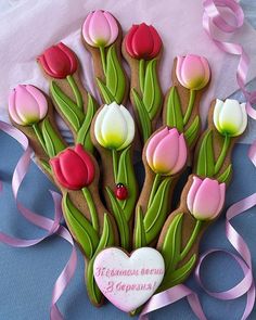 decorated cookies in the shape of tulips and hearts on a blue tablecloth