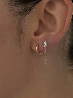 a close up of a person's ear with a chain attached to the back of it