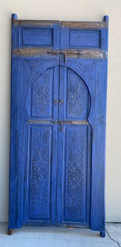 an old blue wooden door on the side of a building