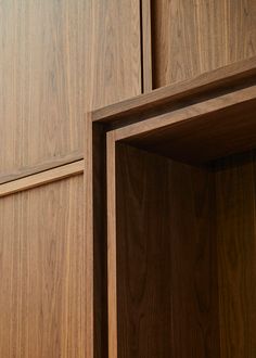 an open wooden cabinet door with wood grained panels on the side and bottom panel