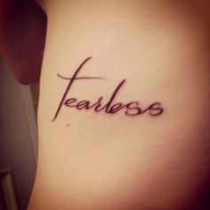 the word fearless written in cursive writing on someone's lower back leg