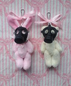 two stuffed animals are wearing gas masks on a pink and white striped background with ribbons