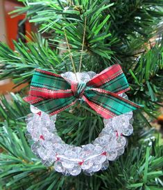 a christmas ornament hanging from a tree with a bow on it's head