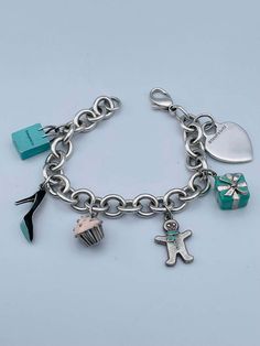 For Sale on 1stDibs - Charming charm bracelet. Made and signed by TIFFANY & CO. Sterling silver bracelet, with a sterling heart charm and five enamel figural charms: a Tiffany Tiffany And Co Charm Bracelet, Designer Enamel Jewelry For Gift, Designer Enamel Jewelry As A Gift, Luxury Logo Charm Bracelet As Gift, Luxury Charm Bracelet With Logo Charm As Gift, Luxury Hallmarked Charm Bracelet Gift, Elegant Charm Bracelet With Logo Charm As Gift, Luxury Jewelry With Dangling Charms For Gifts, Luxury Dangling Charms Jewelry For Gifts