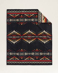 a black blanket with an orange, yellow and red design on the bottom is shown