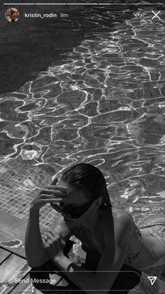 a woman in a bathing suit sitting on the edge of a swimming pool with her hands to her face