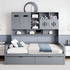 a bed room with a neatly made bed and storage cabinets on the wall above it