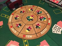 a wooden board game set up on top of a casino table with dices and cards