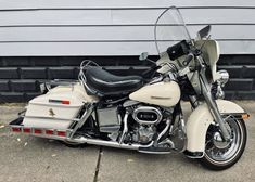 a white motorcycle parked in front of a garage