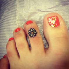 a woman's toe with a flower tattoo on it