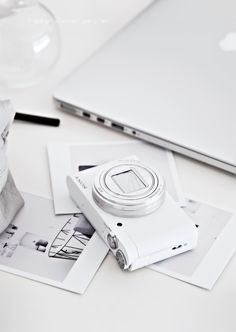 an apple laptop computer sitting on top of a white table next to other electronics and papers