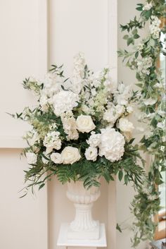 a white vase filled with lots of white flowers