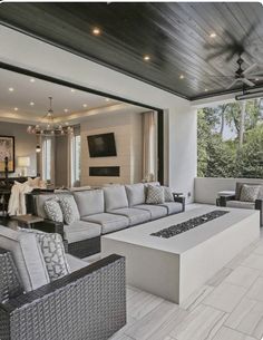 a living room filled with furniture and a fire place in front of a large window