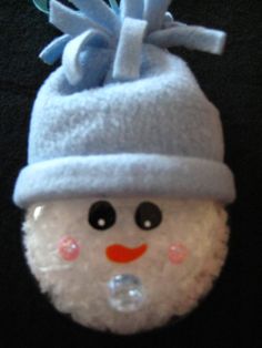 a white snowman ornament with a blue hat on it's head