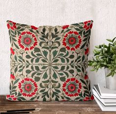 a pillow sitting on top of a wooden table next to a potted plant and books