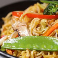 noodles, broccoli and carrots in a black bowl