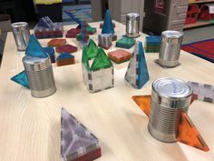 several tin cans with different shapes and sizes sitting on a table