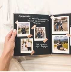 a hand holding an open photo book with pictures on the pages and photos taped to it