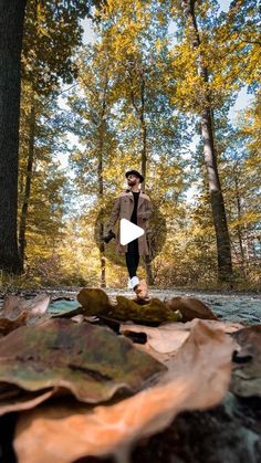 a man is running through the woods with leaves on the ground