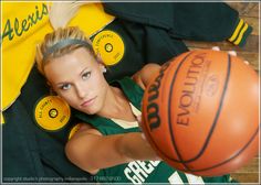 a woman in green jersey holding a basketball