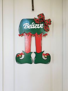 a door hanger that says believe on the front and side of it, decorated with christmas decorations