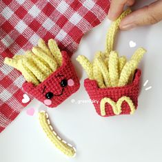 two crocheted hotdogs and fries are sitting on a table