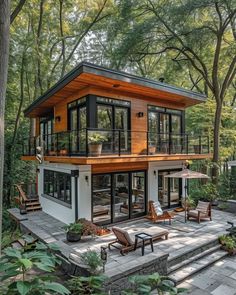 a small house in the woods with lots of windows and doors on it's sides