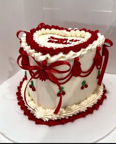 a white and red decorated cake sitting on top of a table