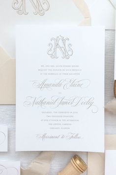 the wedding stationery is laid out on top of white paper and gold foiling