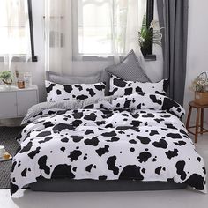 a black and white cow print comforter on a bed