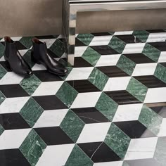 a pair of black and white shoes sitting on top of a checkerboard floor