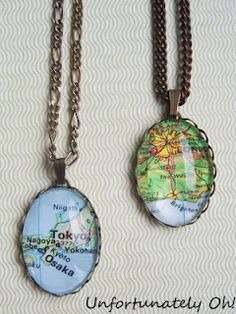 two necklaces with the map on them and chain attached to each one's neck