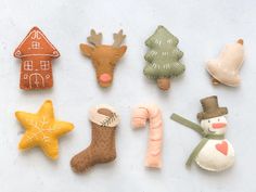 felt christmas decorations are arranged on a white surface