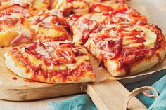 a pizza sitting on top of a wooden cutting board