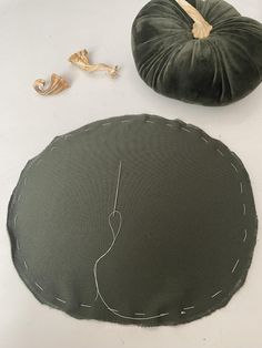 two pieces of fabric sitting on top of a table next to a pumpkin shaped pillow