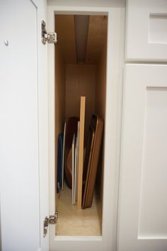 an open cabinet with several pieces of luggage in the bottom drawer and one piece of wood sticking out of it