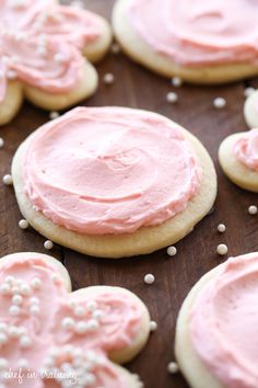 pink frosted cookies on a wooden table