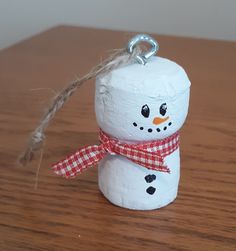 a snowman made out of toilet paper on top of a wooden table