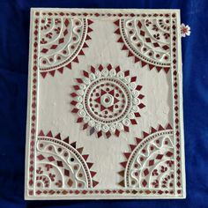 an intricately designed white and red paper cutting board on a blue cloth covered surface