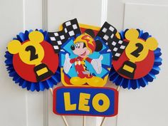 a mickey mouse cupcake topper with the name leo on it and some decorations