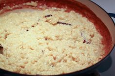 the food is being cooked in the pan on the stove top with a spoon inside