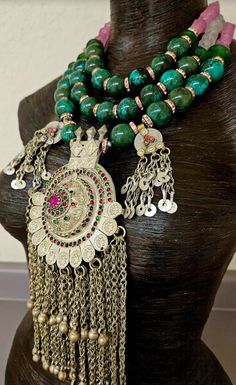 Huge 20 mm luxury turquoise round beads are each separated by pink rhinestone rondelles in this big, bold, heavy and dramatic showstopper tribal - ethnic beaded chest piece. The back of the necklace is finished with two shades of frosted pink glass beads and silver tone tribal spacers. The focal point is a big vintage Waziri Architectural Dome Pendant which measures approximately 9.5" x 4.5". The pink and green inlaid glass is intact, as are all the chain dangles. Two smaller charm dangles flank Beaded Jewelry For Rituals And Festivals, Bohemian Wedding Beads, Traditional Handmade Beads And Cabochons For Festivals, Handmade Traditional Beads And Cabochons For Festival, Traditional Green Beads For Festival, Traditional Handmade Turquoise Beads, Bohemian Turquoise Beads For Festivals, Turquoise Bohemian Beads For Festivals, Traditional Green Beaded Necklace For Festival